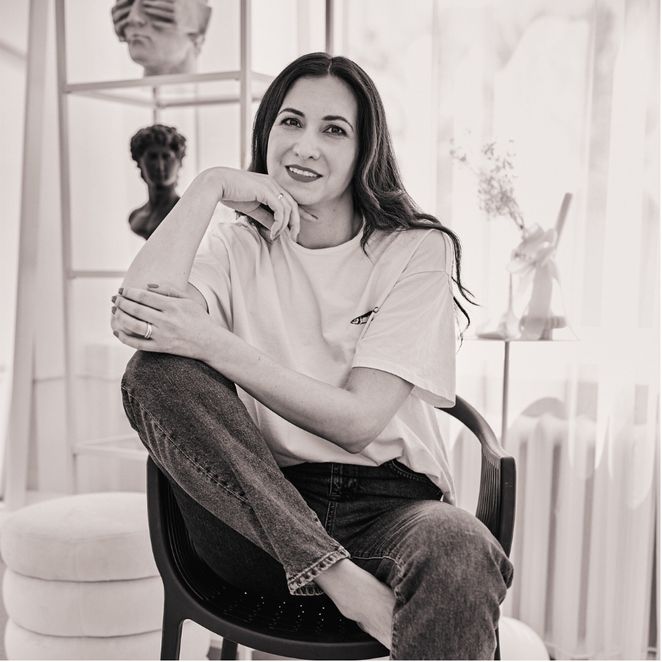 Dziewczyna siedzi na krześle, rękę opiera o kolano